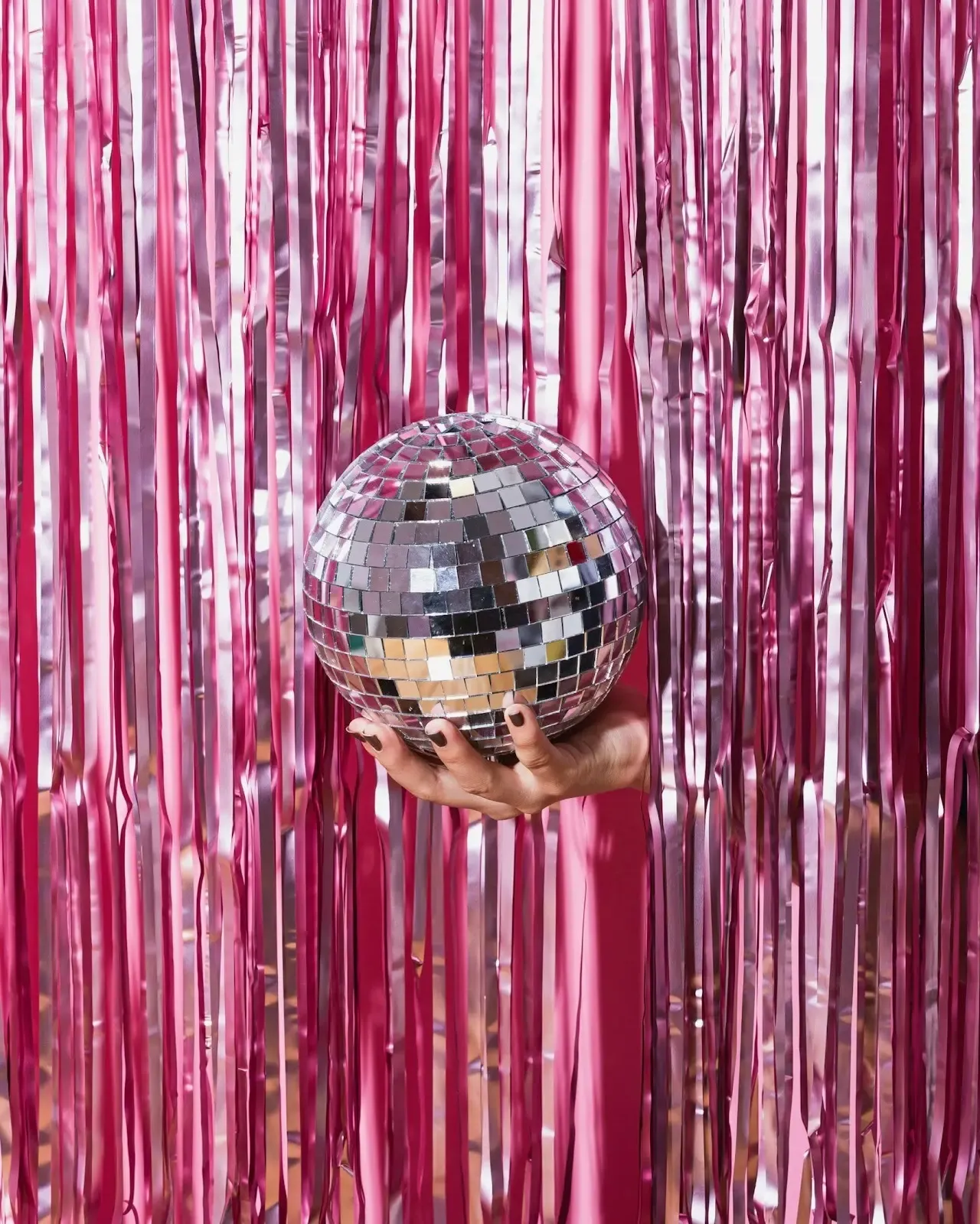 pink disco ball in hand